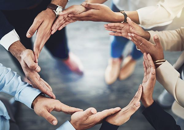 Hands overlapping to form an open circle with the text that reads Meet  Our Team