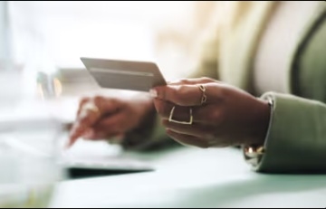 person holding credit card over a keyboard