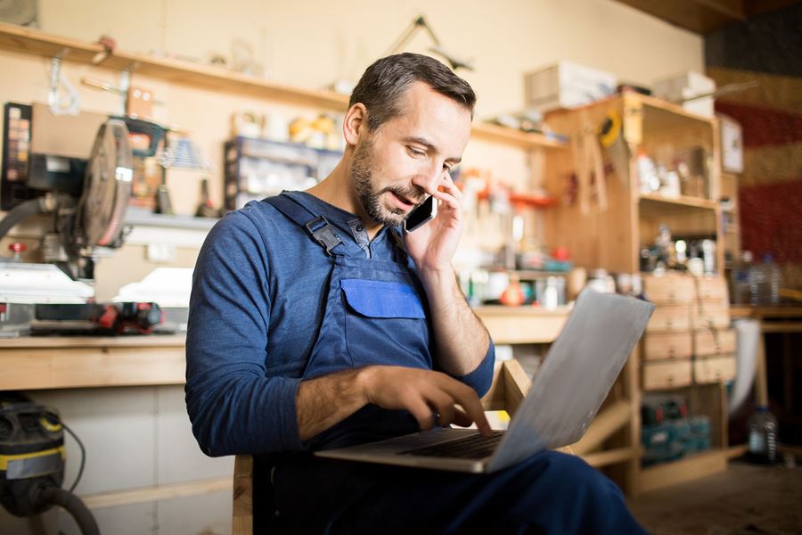 man on the phone while working on a laptop