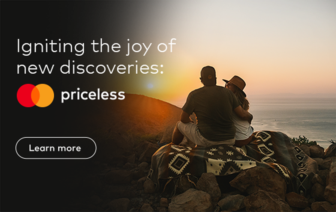 Photo of a couple sitting on the hilltop facing the sunset overlooking the next hilltop. Text Overlay saysZ: Igniting the joy of new discoveries: Priceless. Mastercard logo, button which reads: Learn more.